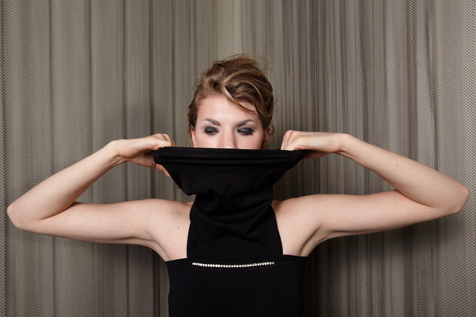 Model Chloe in front of a chainmail curtain in a DH Studios design.
