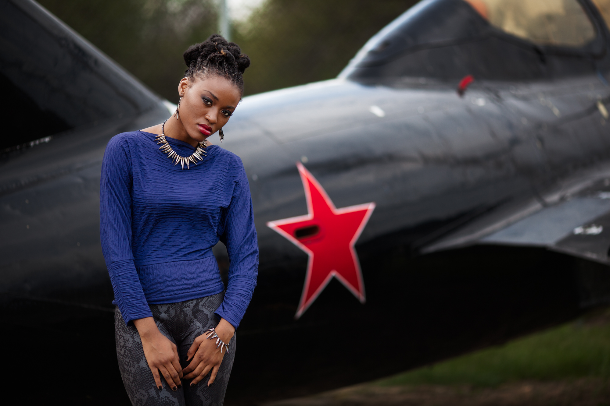 Model showing off DH Studios 2012 collection in front of a MiG-21.