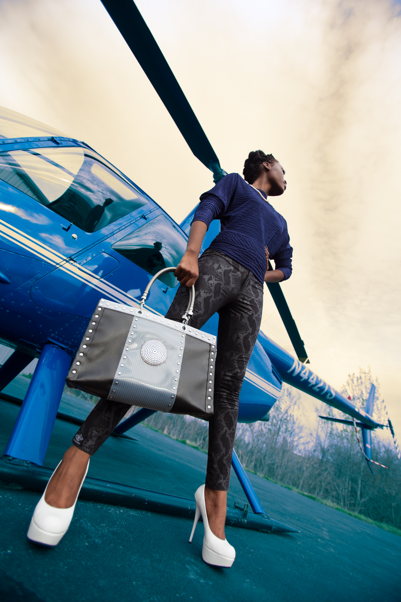 Model showing off DH Studios 2012 collection in front of a helicopter.