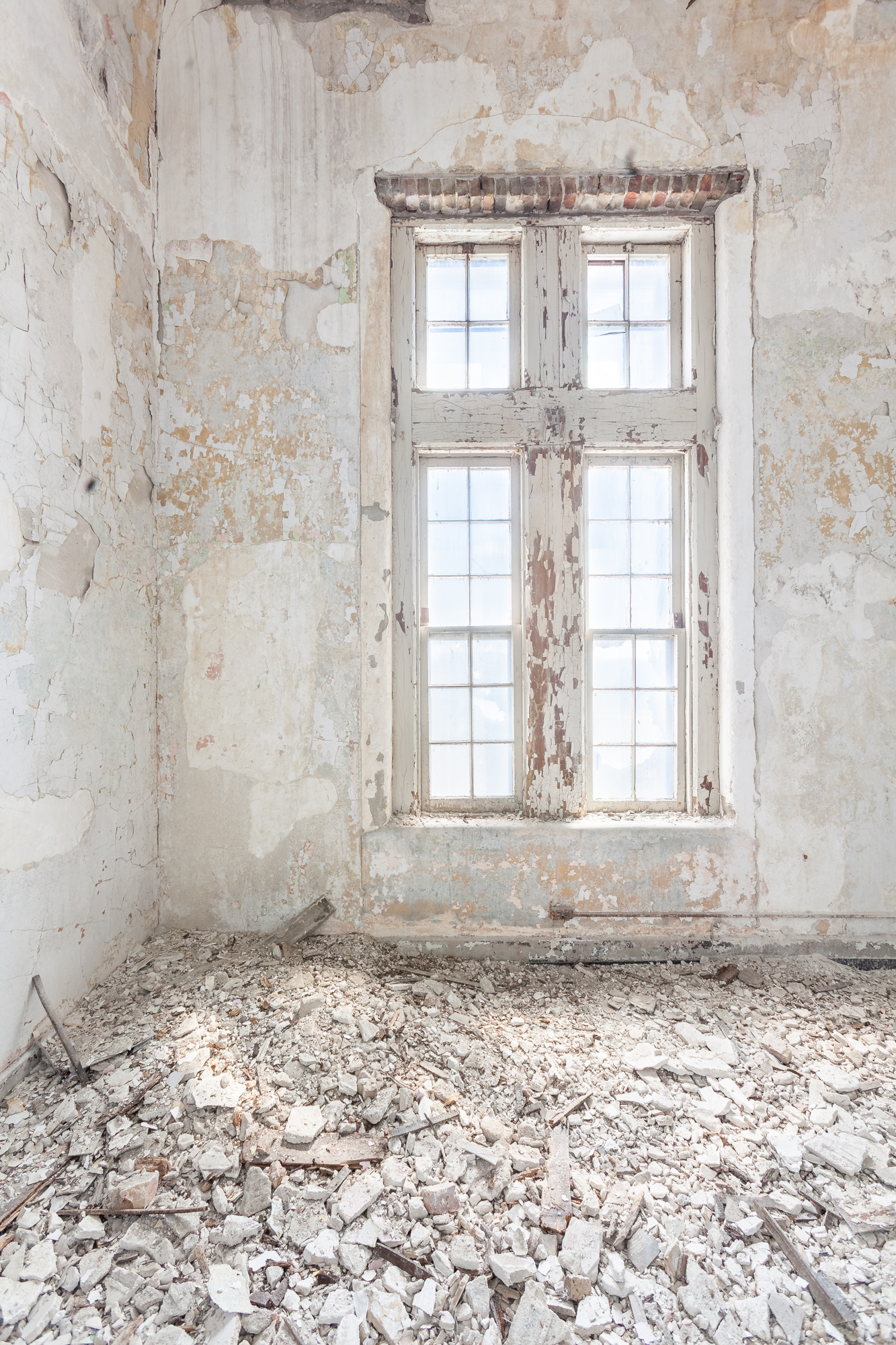 White room with crumbling plaster at Buffalo State Hospital