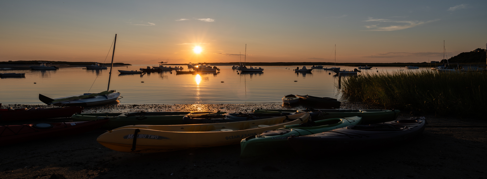 Photograph of boats at sunset in Pamet Harbor in Truro, MA.