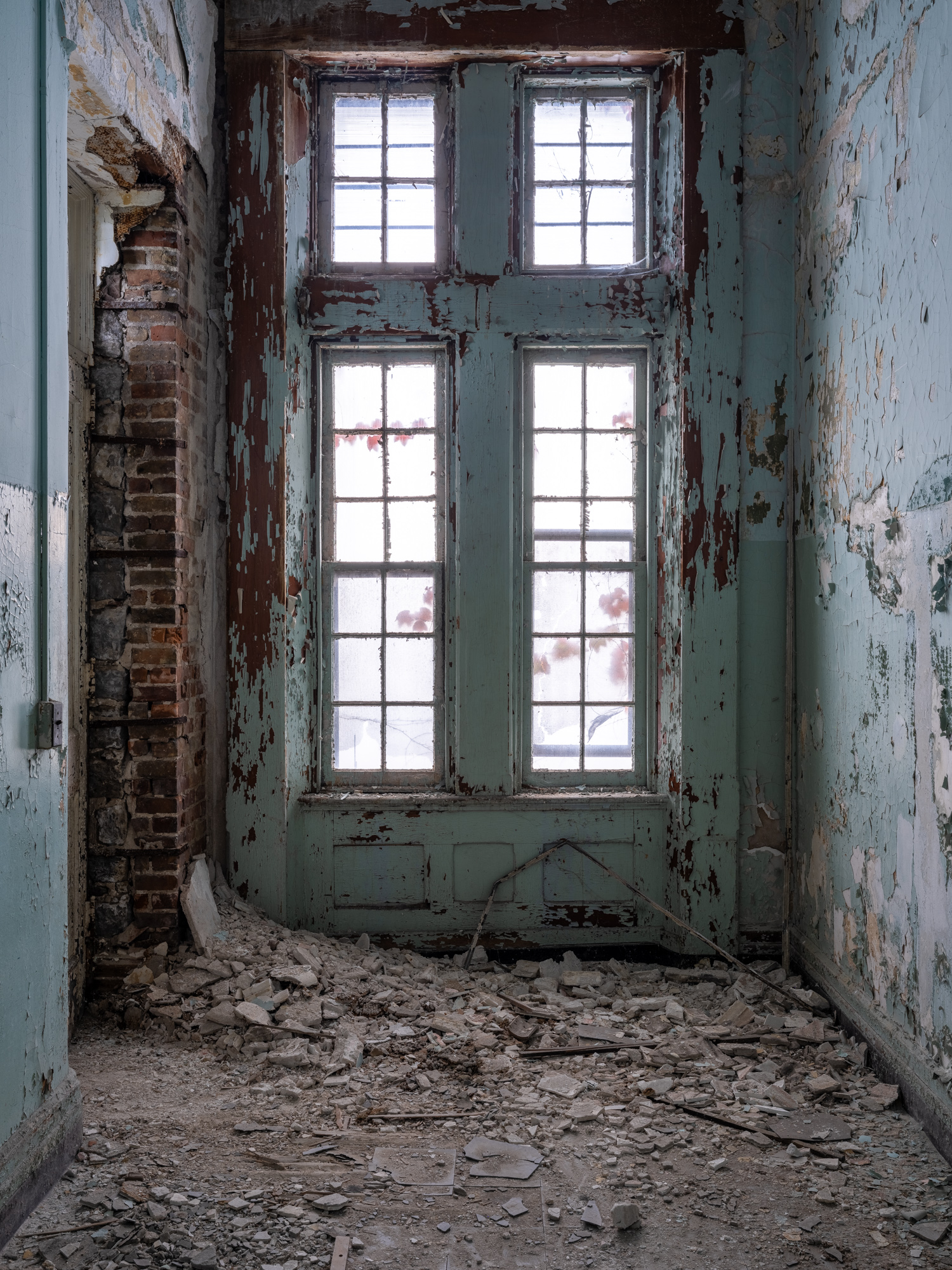 Crumbling hospital green windows and door at Buffalo State Hospital