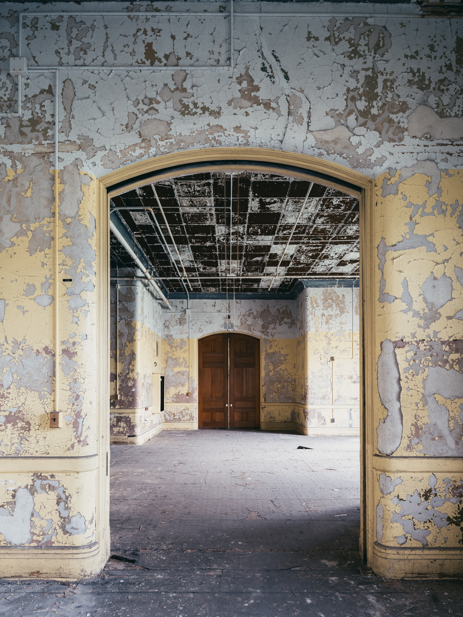 Yellow hallway and wooden doors at Buffalo State Hospital