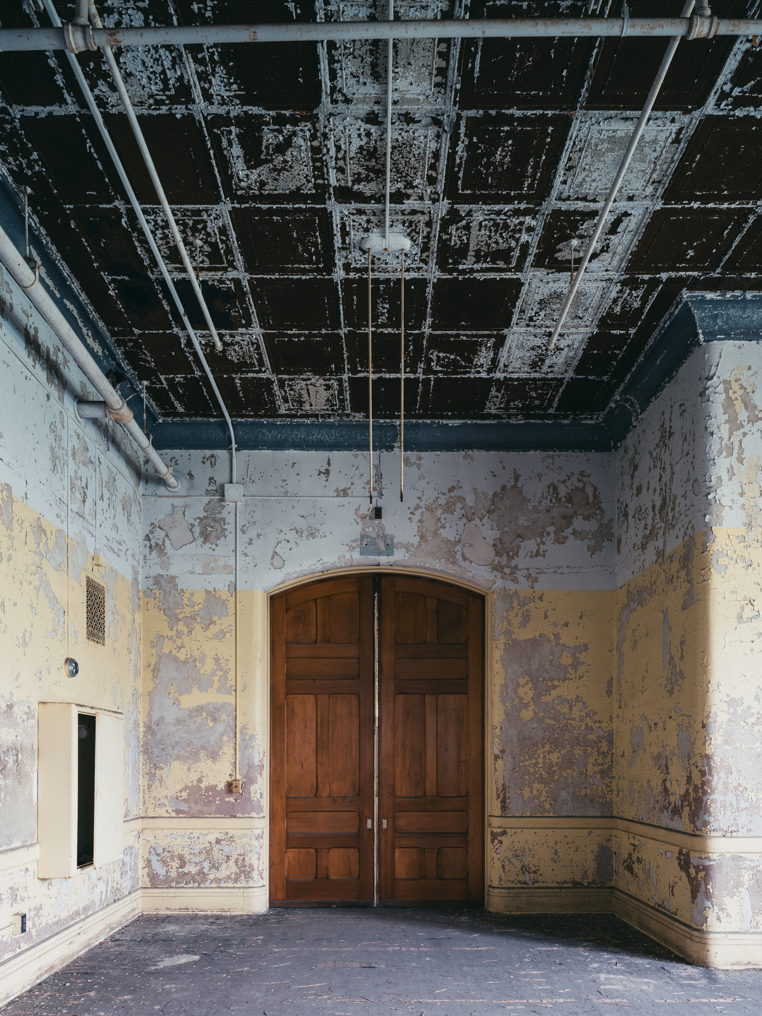 Yellow hallway and wooden doors at Buffalo State Hospital