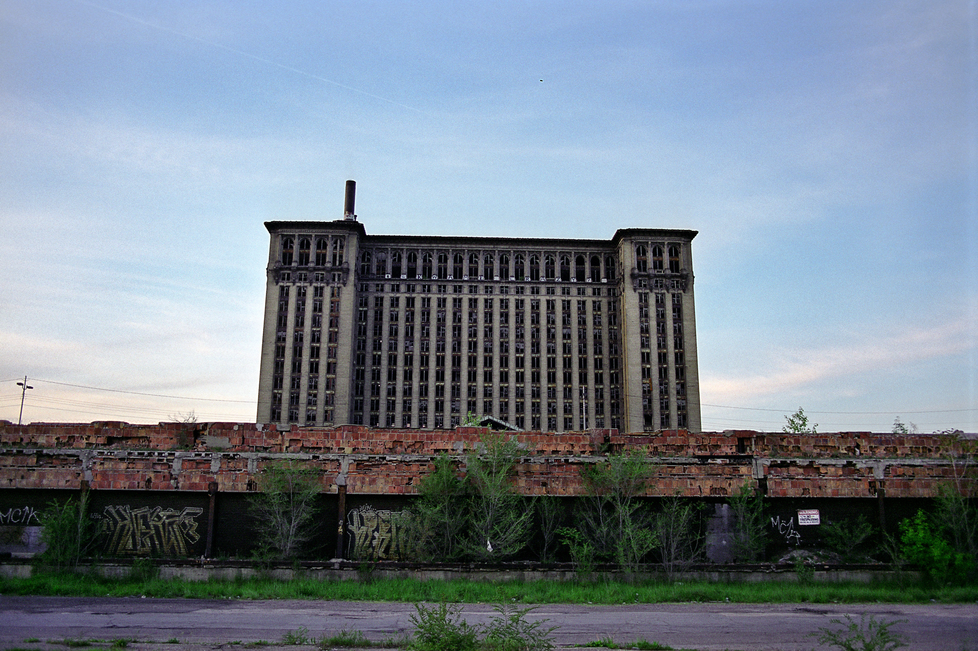 Exterior view from behind train tracks of Michigan Central Station in Detroit, MI.